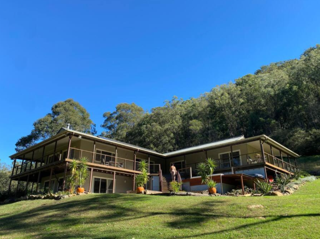A serene indoor meditation circle at Yanada Retreat, featuring yoga mats and signature purple bolsters arranged in a welcoming circle on polished timber floors. An intentional and sacred space prepared for a Mystique Moksha wellness session